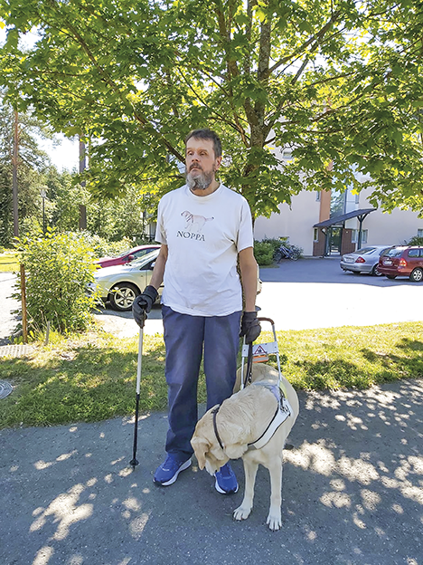 Kari HJ Oja opaskoiransa Camryn kanssa puistikossa kotitalonsa edustalla.